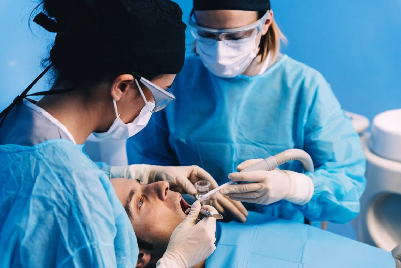 Dentist and assistant during surgery at the dental clinic